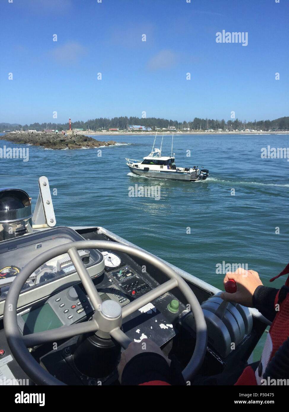 Un bon Samaritain à bord d'un navire de pêche transporte une personne tiré de l'eau après que le bateau a chaviré à 500 mètres de côté Rock de la Push, le 17 août, 2016. Une station de la Garde côtière canadienne Quillayute River accompagné de l'équipage du bâtiment après qu'il est devenu handicapé, en route vers la gare, où le personnel médical d'urgence étaient en attente. U.S. Coast Guard photo gracieuseté de Quillayute River Station. Banque D'Images