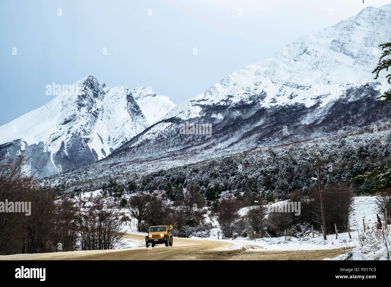 Un véhicule hors route de disques sur la route entre le parc national de la Terre de Feu et Ushuaia. La neige récente donne à la magie pour le paysage. Banque D'Images