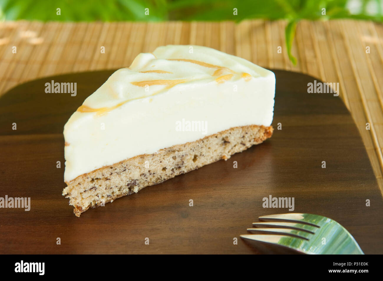 Tranche de gâteau avec de la crème glacée Crème glacée à la vanille sur pain de banane avec un tourbillon de caramel sur une plaque de bois Banque D'Images