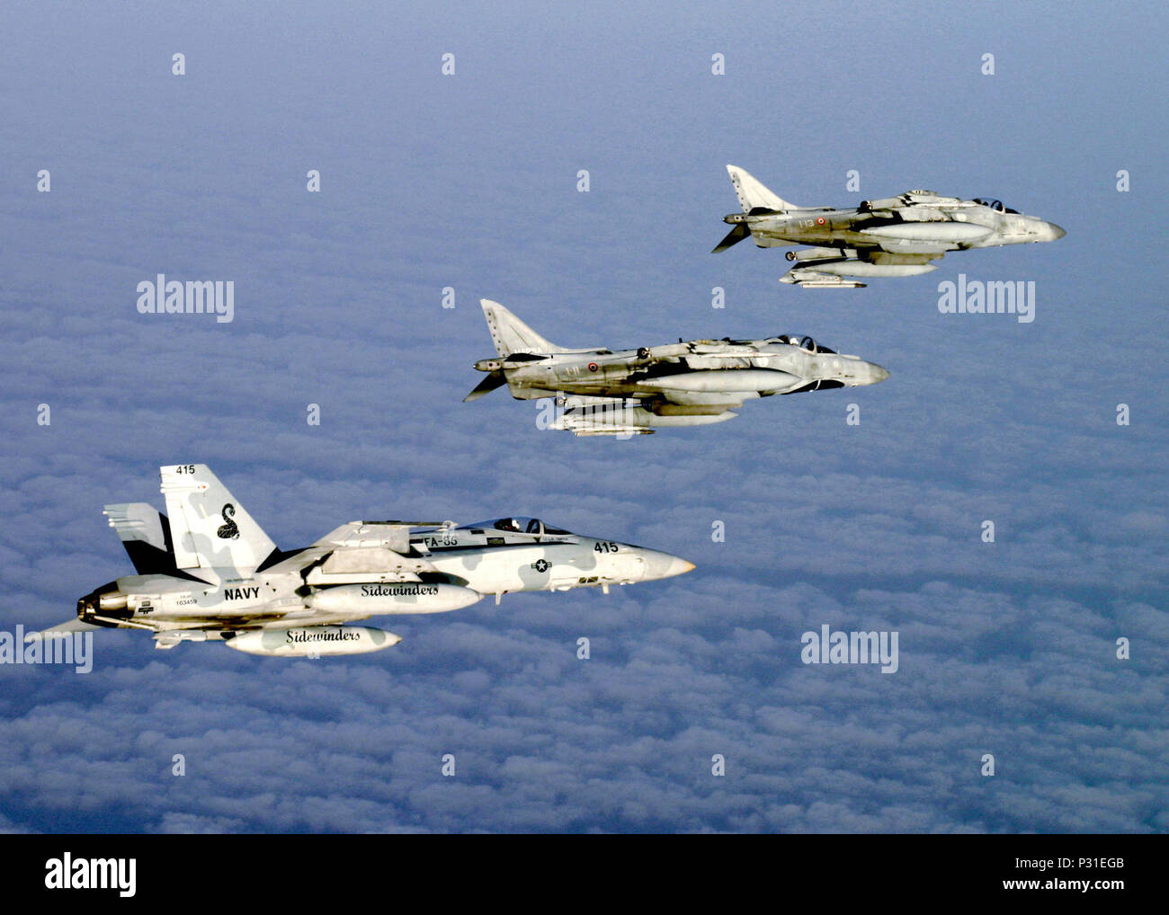 Océan (10 juillet 2004) - Au-dessus des nuages sur l'Océan Atlantique d'un F/A-18C Hornet affectés à l'idewinders' de Strike Fighter Squadron Huit Six (VFA-86) vole en formation avec deux italiennes AV-8B Harrier II + affecté à la Marine italienne porte-avions SON Giuseppi Garabaldi (C 551), à la suite d'entraînement au combat aérien dissemblables (DACT). L'avion font partie de l'aigle majestueux, un exercice multinational qui se déroulera au large des côtes du Maroc. L'exercice démontre la force combinée des capacités et des temps de réponse rapide de l'air, de la marine, participants et sous-marine de guerre de surface g Banque D'Images
