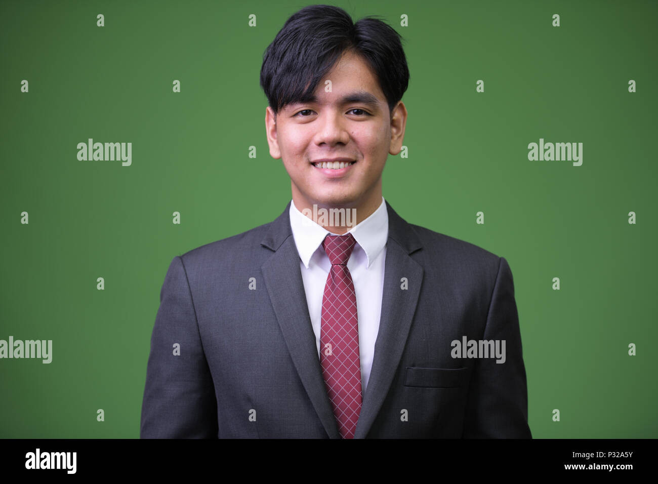 Beau jeune homme d'Asie contre l'arrière-plan vert Banque D'Images