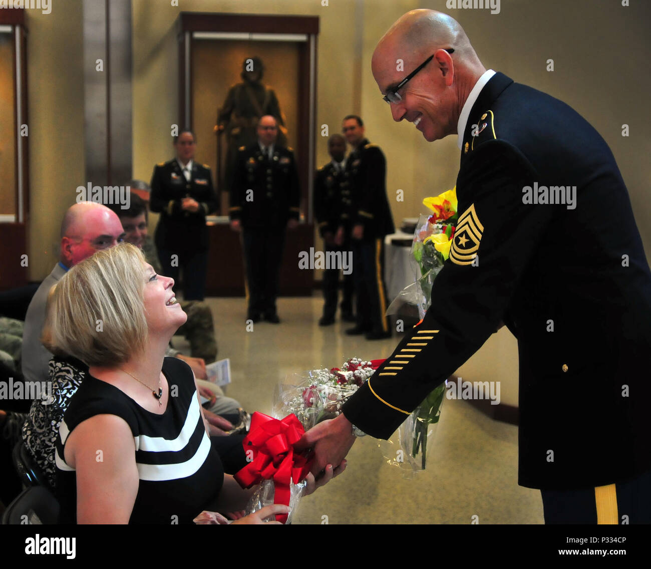 Le Sgt. Le Major Paul J. Klikas donne à sa femme le 22 juillet, 2016 fleurs, à Marshall Hall, Fort Bragg, Caroline du Nord dans le cadre d'une célébration de la retraite pour le Colonel Charles E. Newbegin et lui-même. (U.S. Photo de l'armée par la FPC. Hubert D. Delany III) Banque D'Images