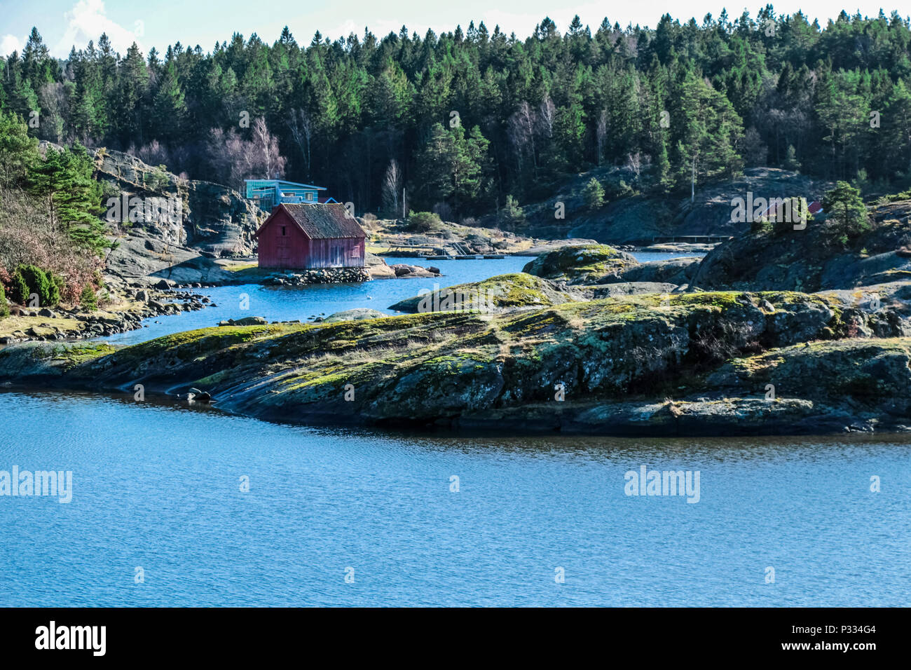 Maison typiquement suédois sur un lac entouré de pins Banque D'Images