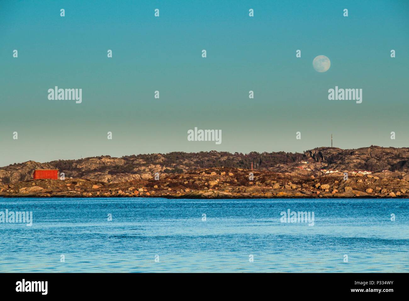 Soirée Pastel sur la côte suédoise avec grande lune au-dessus de la ville de l'île Banque D'Images