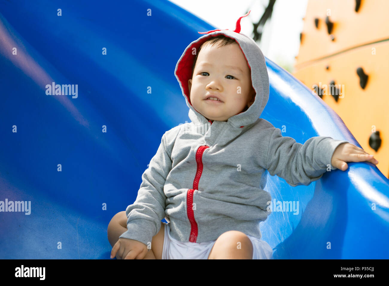 Petit bébé asiatique Garçon jouant slide Banque D'Images