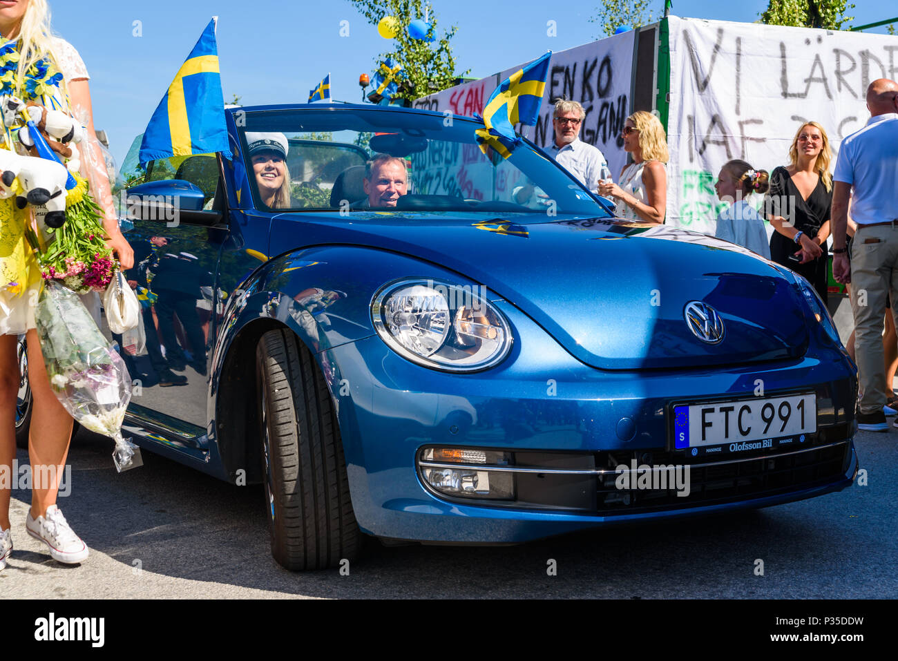Ronneby, Suède - 15 juin 2018 : l'école secondaire supérieure le jour de graduation. Happy female student équitation loin dans une Volkswagen Beetle 2015 bleu de l'école Banque D'Images