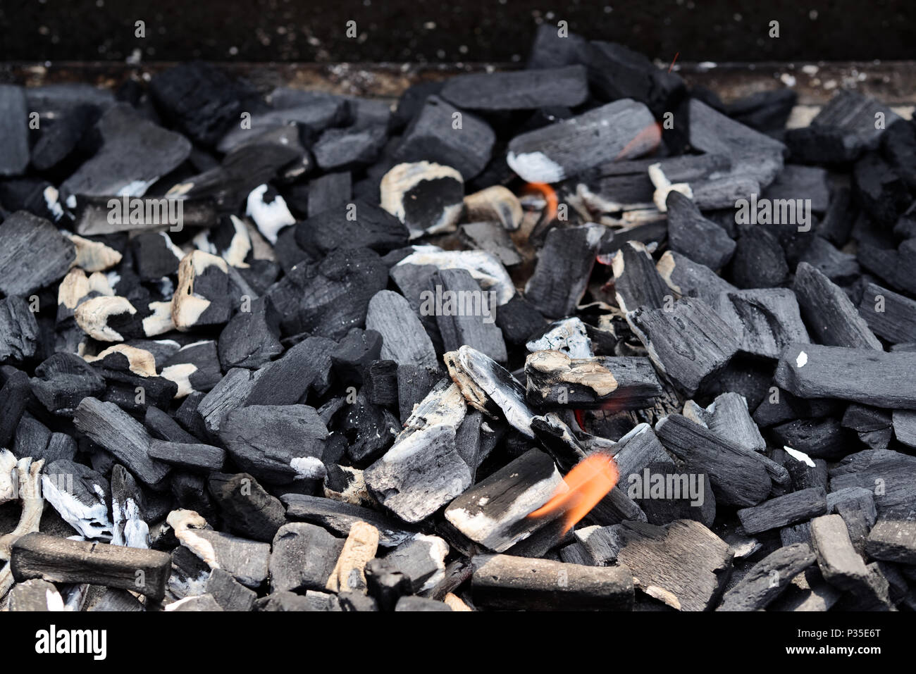 Vue de dessus du charbon chaud dans un ciel lumineux grill. Résumé Contexte de charbon, de texture ou de papier peint. Des charbons pour la cuisson des aliments sur le gril. Banque D'Images