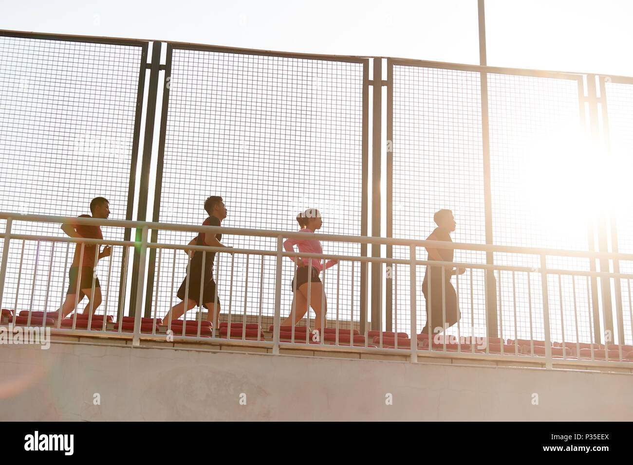 Une équipe de jeunes adultes hommes et femmes asiatiques qui tourne au-dessus de grand stand au stade. Banque D'Images