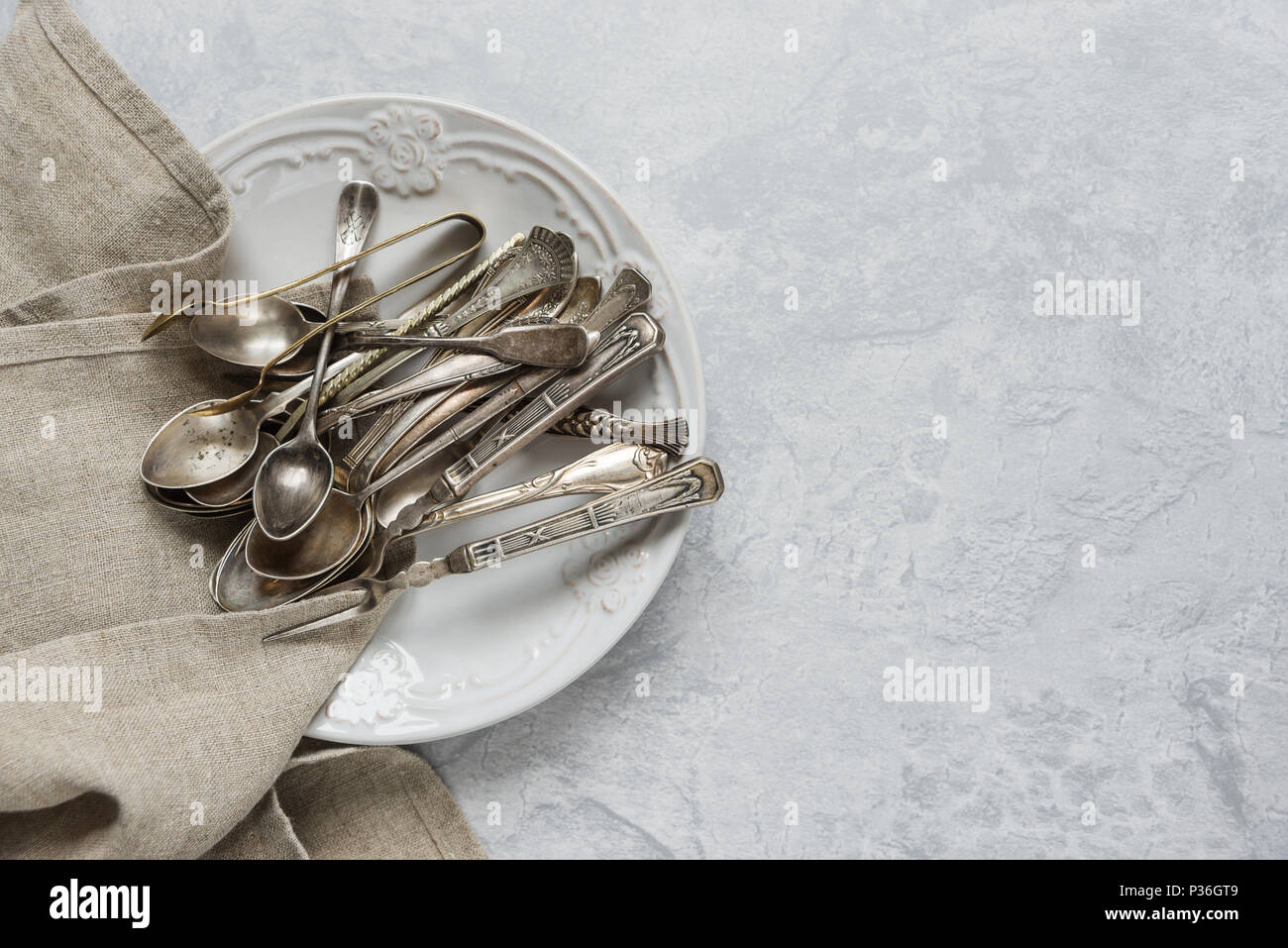 Divers meubles anciens de l'argenterie sur plaque en céramique sur l'arrière-plan de surface de béton gris, avec l'espace de copie Banque D'Images