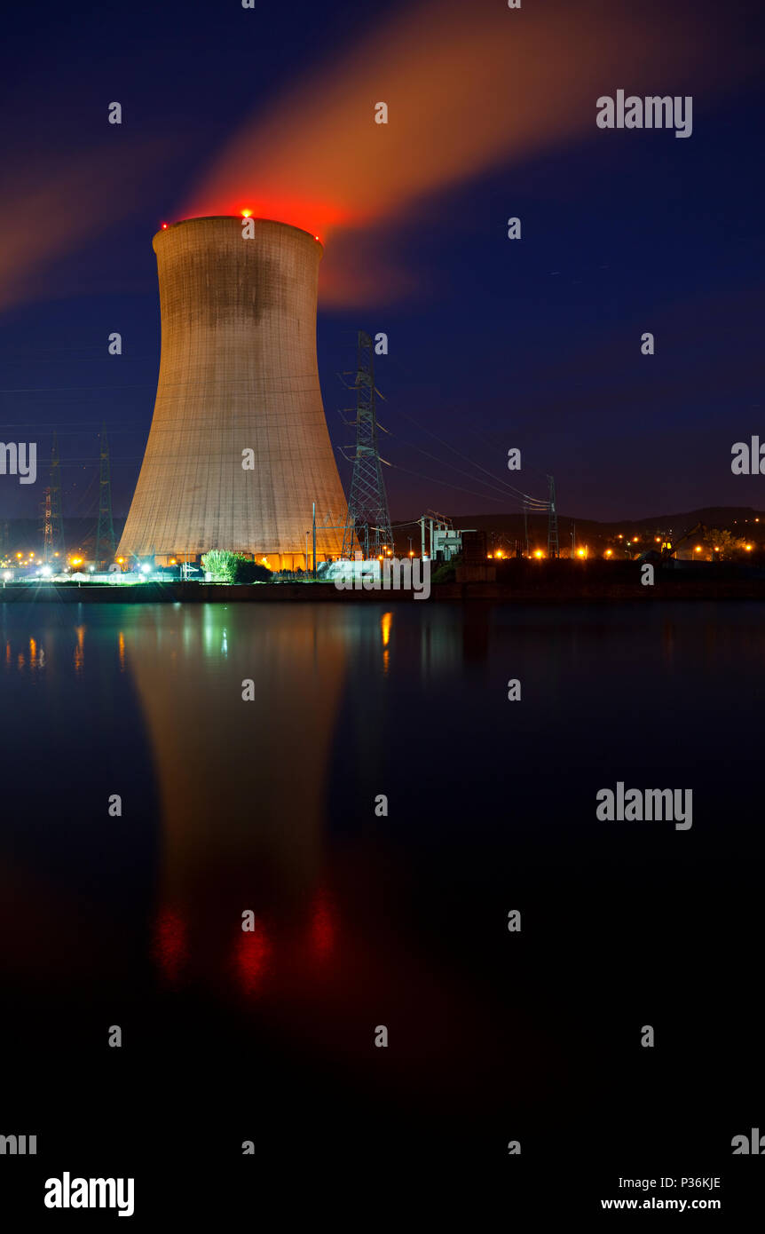 Photo de nuit d'une grande centrale nucléaire à proximité d'une rivière avec bleu ciel de nuit. Banque D'Images