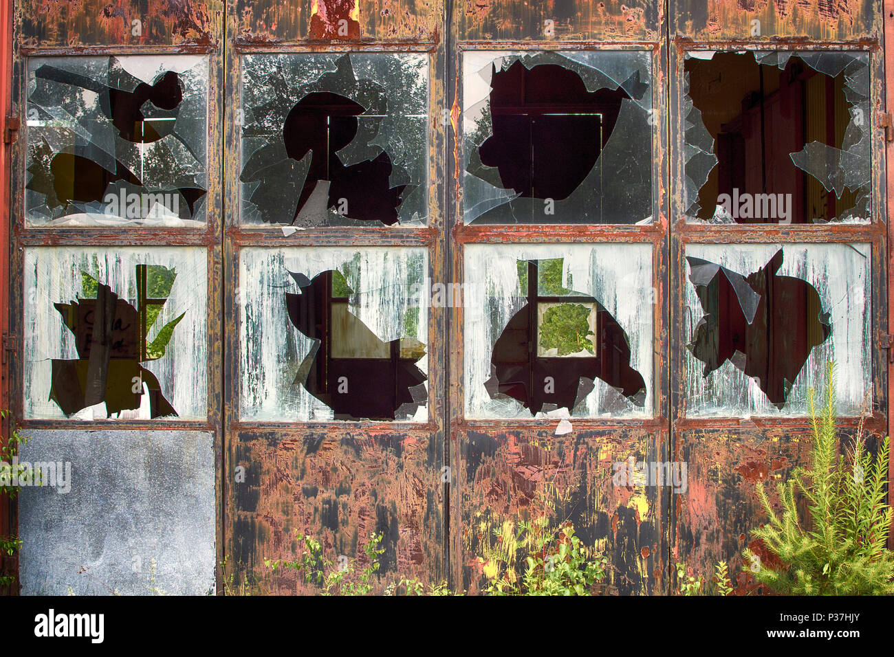 Des fenêtres cassées à old rusty bâtiment industriel. Banque D'Images