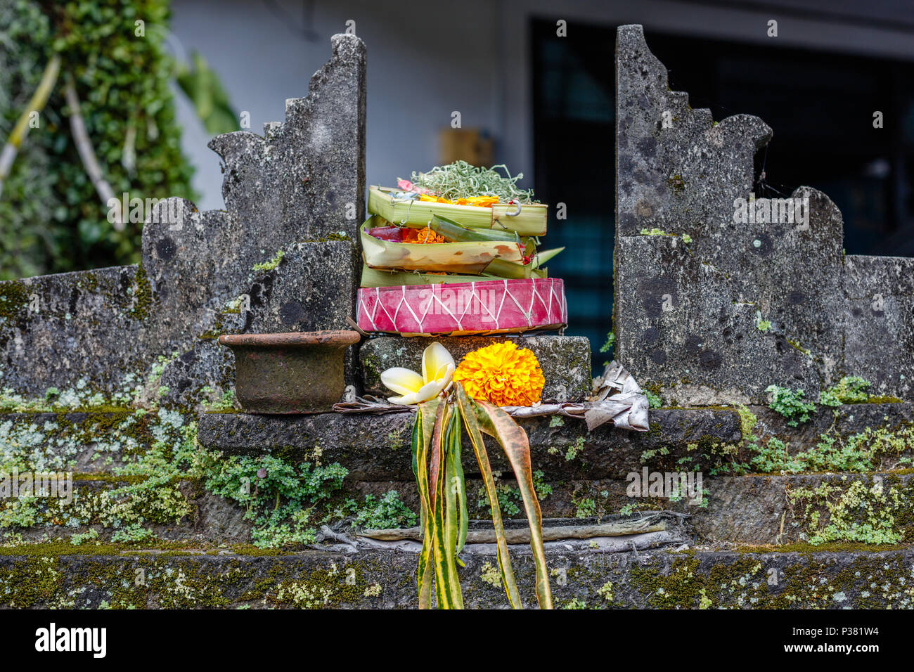 Offres balinais hindou traditionnel canang sari à l'autel de pierre. Bali, Indonésie. Banque D'Images