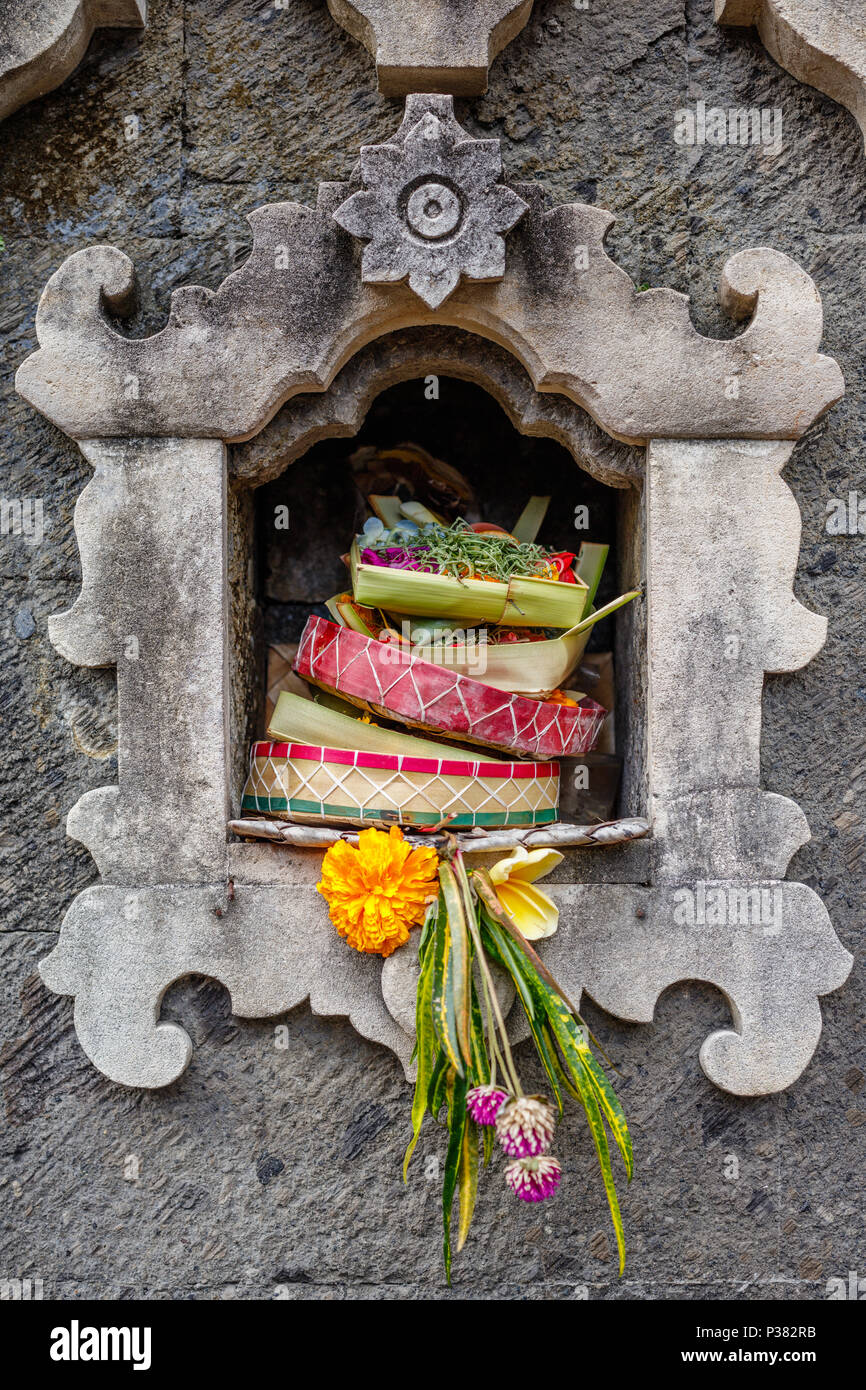 Offres balinais hindou traditionnel canang sari à l'autel de pierre. Bali, Indonésie. Banque D'Images