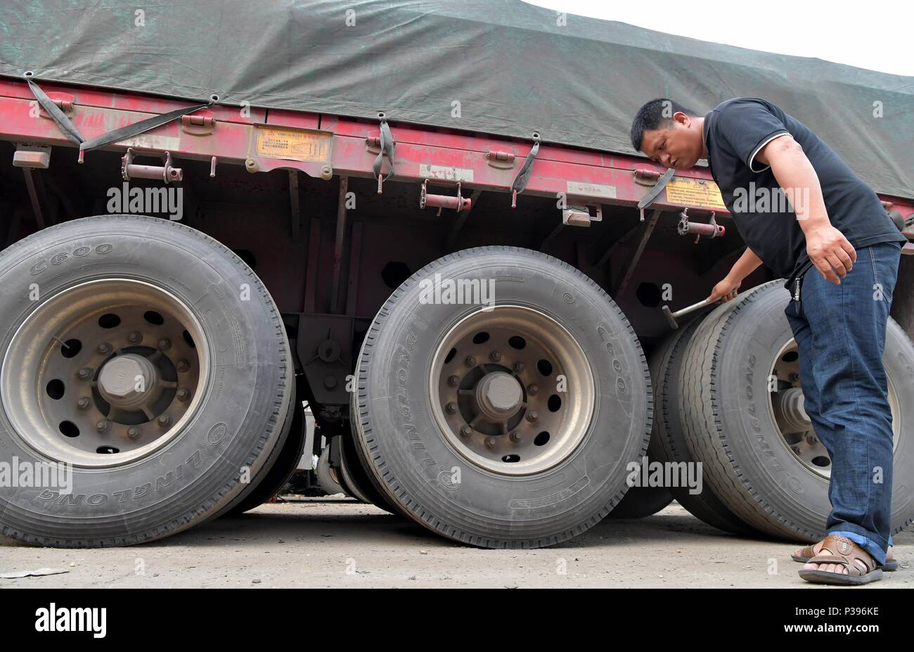 (180618) -- NANCHANG, 18 juin 2018 (Xinhua) -- Zou Yujiang pneus vérifie avant de partir à Gao'an City, province de Jiangxi, Chine orientale, le 12 juin 2018. Zou Yujiang, 41 ans, est un chauffeur de camion de Gao'an, Ville de la province de Jiangxi. Il a passé la majeure partie de son temps sur la route, le transport des marchandises d'un endroit à l'autre. Il y a eu plus de 21 millions d'employés dans l'industrie du transport routier de marchandises en Chine jusqu'à présent. Comme Zou Yujiang, la plupart d'entre eux vivent sur les chariots avec peu de temps d'un séjour avec les familles. Leur travaux ont contribué à la livraison rapide et fiable Banque D'Images