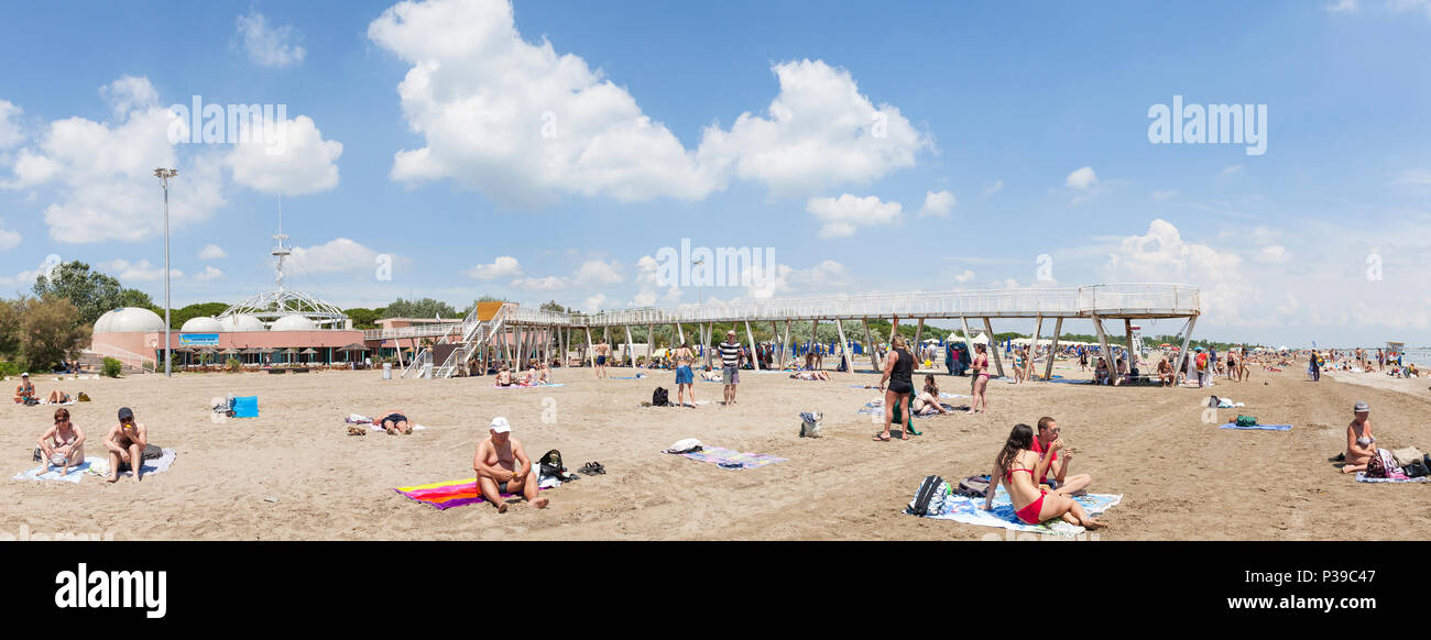 Panorama de Blue Moon Beach, Lido di Venezia, Venise, Vénétie, Italie à la fin du printemps à l'embarcadère et des restaurants, les gens nager et bronzer Banque D'Images