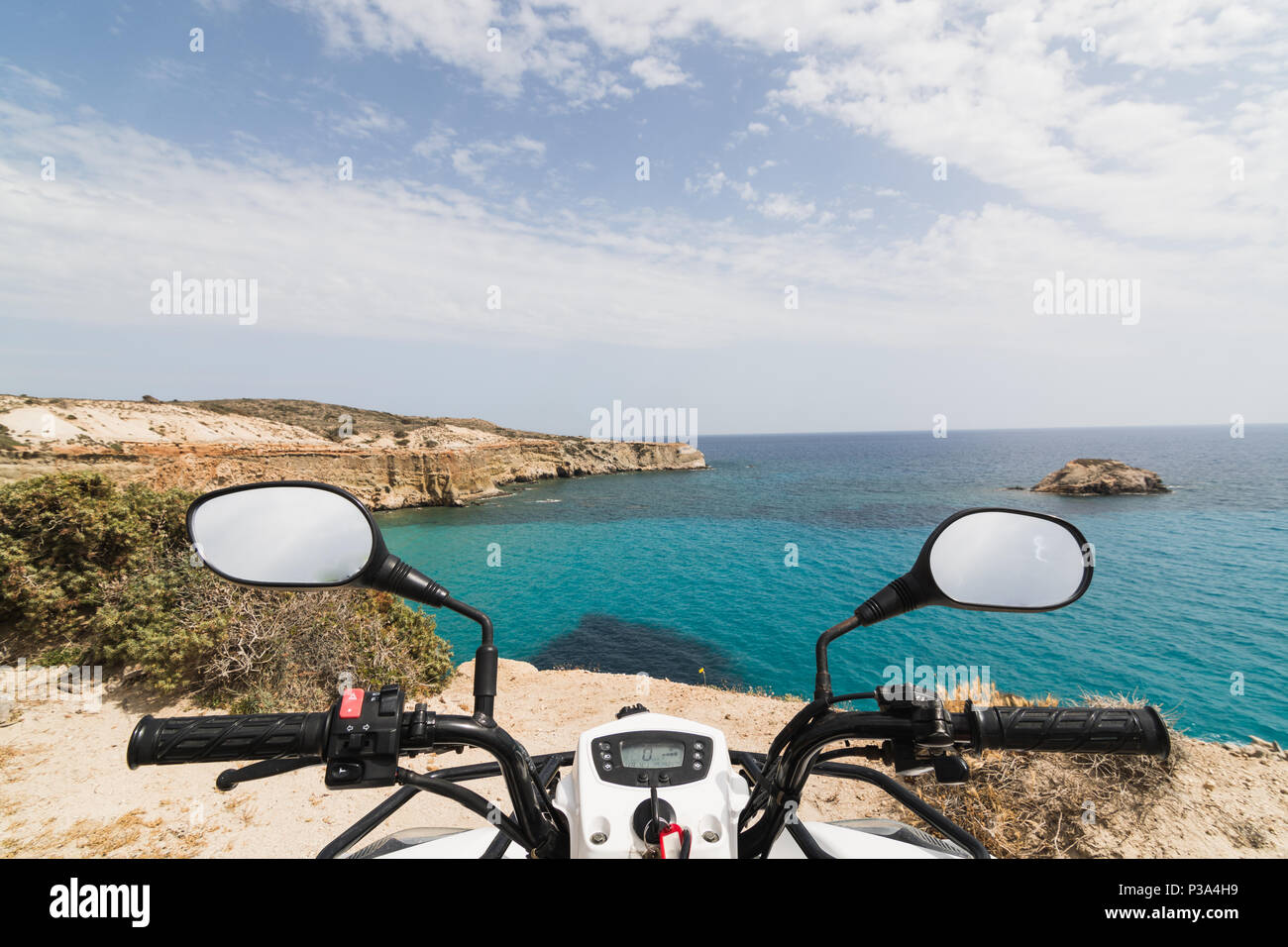 ATV quad garé sur le bord de mer sur l'île de Milos, en Grèce. Vue depuis le siège du conducteur Banque D'Images ATV quad garé sur le bord de mer sur l'île de Milos, en Grèce. Vue depuis le siège du conducteur Banque D'Images