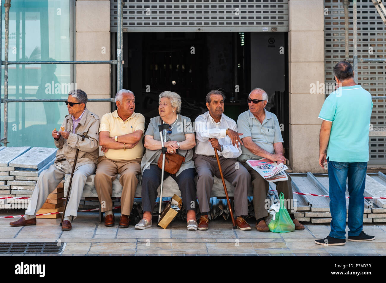 Groupe de personnes âgées l'espagnol les hommes et les femmes se rassemblent pour un chat à Malaga, Espagne. Banque D'Images