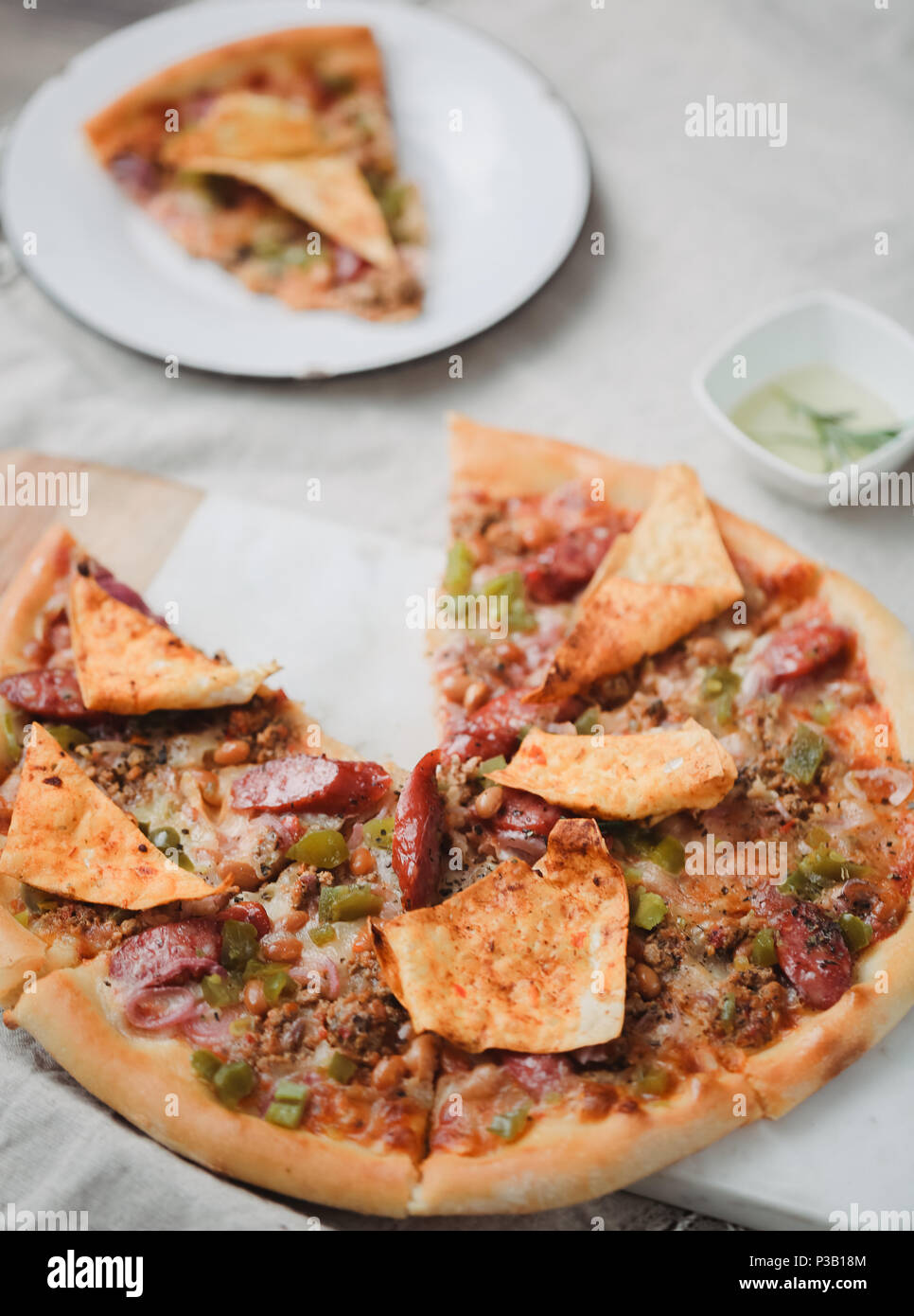 Pizza italien frais. La photographie alimentaire pour la conception. Pizza mexicaine avec les morceaux, l'oignon, piment jalapeno chaud sur une fine couche de pâte classique. Photo gros plan de coupe. Banque D'Images