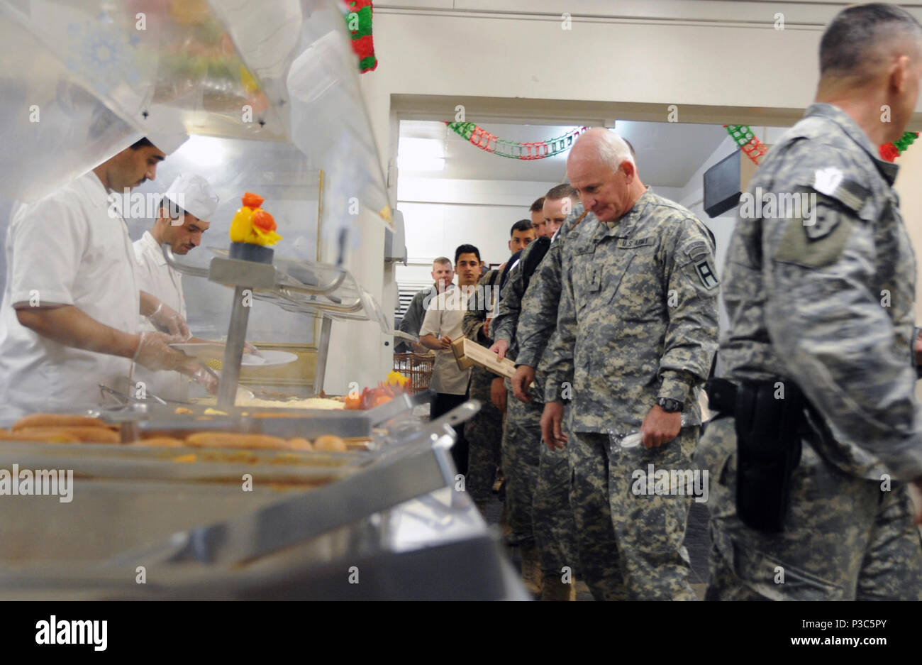 Kaboul, Afghanistan - Le Lieutenant Général Thomas G. Miller, général commandant la Première armée, centre, étudie l'alimentation choix dans la "chèvre" de la salle à manger à Camp Eggers, l'Afghanistan, avant qu'une stratégie le dîner le 10 décembre 2009. La réunion était organisée par le Général William B. Caldwell, IV, commandant de la Mission de formation de l'OTAN - l'Afghanistan, et comprenait le général Michael Bednarek, commandant de la Première Division de l'armée est, Brig. Le général Gary S. Patton, général commandant adjoint, Programmes, et Brigue. Simon Levey, commandant de l'entraînement combiné Groupe consultatif. Les généraux ont discuté d'une meilleure utilisation des forces militaires de réserve Banque D'Images