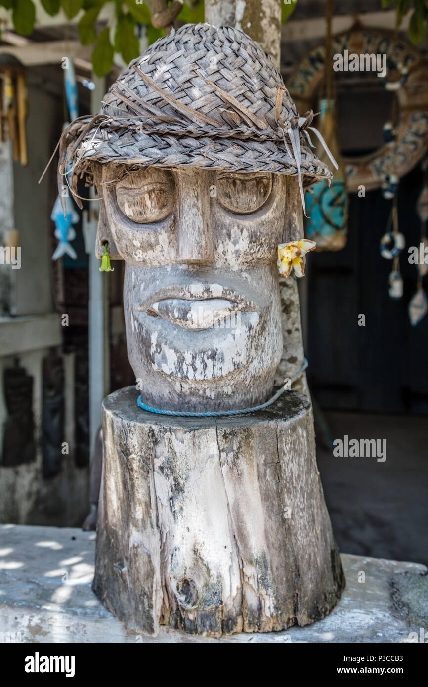 Statue en bois sculpté dans un style balinais traditionnel chapeau de paille près d'une maison locale, Nusa Lembongan, Indonésie Banque D'Images