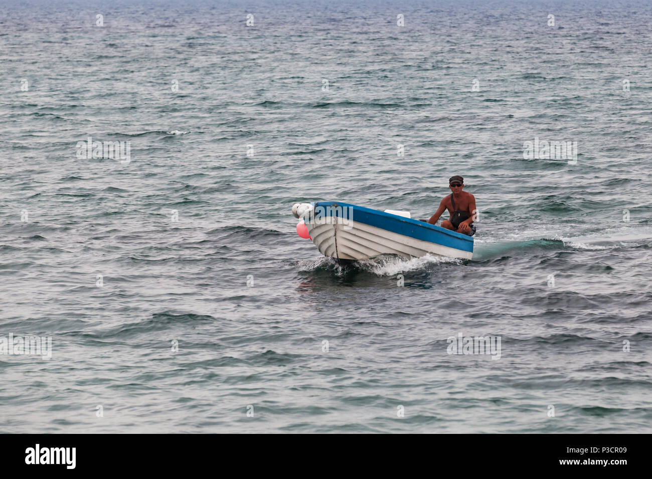 Ayia Napa, Chypre - 16 juin 2018 : pêcheur sur motor yacht en bois blanc va sur l'eau de mer bleue Banque D'Images