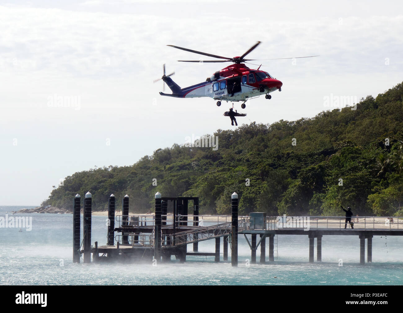 Victime d'accident en civière étant ramené à bord d'hélicoptère en vol stationnaire, Fitzroy Island, Grande Barrière de Corail, Queensland, Australie. Pas de monsieur ou PR Banque D'Images