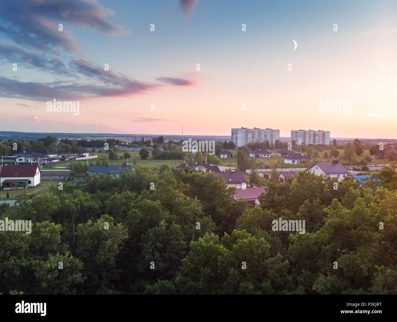 Vue de l'air pour la forêt, les maisons et les champs du village. Un accueil chaleureux peut coucher du soleil. Banque D'Images