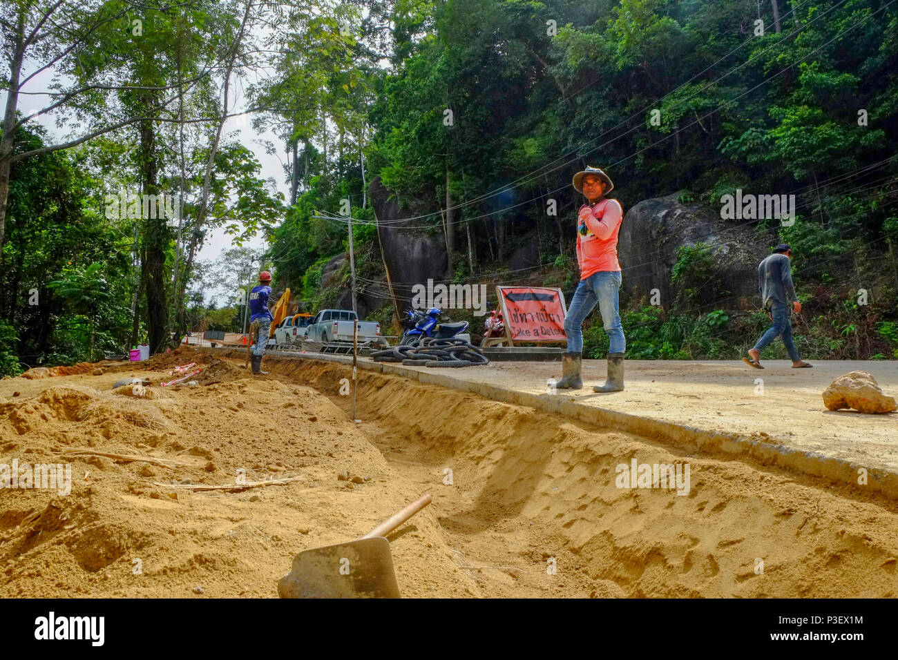 Les travailleurs de la construction du Myanmar sont la construction de nouvelles routes à travers les jungles couvrant les montagnes de l'île thaïlandaise de Koh Phangan, Thaïlande Banque D'Images