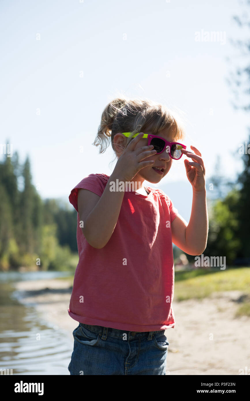 Cute girl wearing sunglasses près de River Bank Banque D'Images