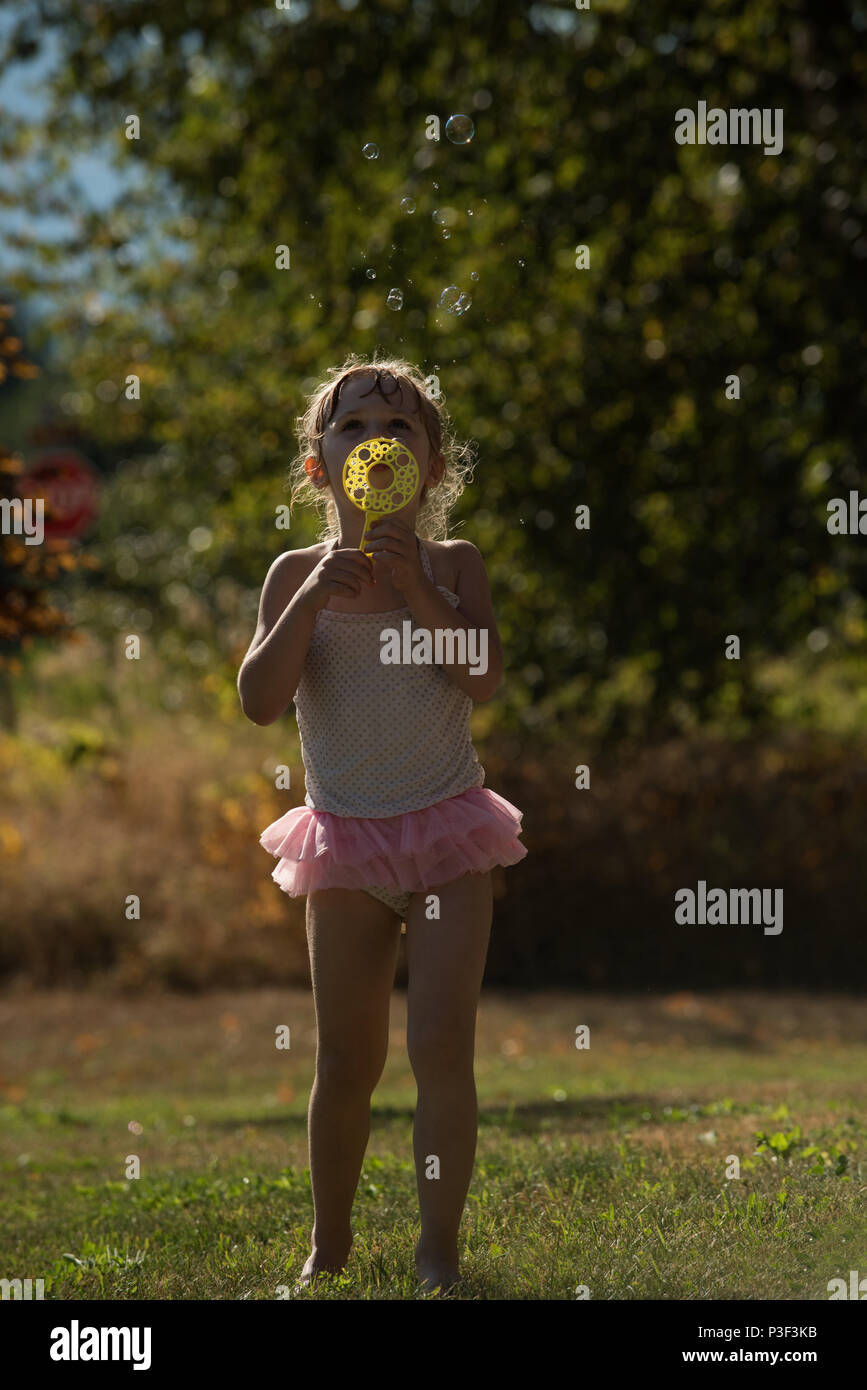 Cute girl Playing with bubble wand Banque D'Images