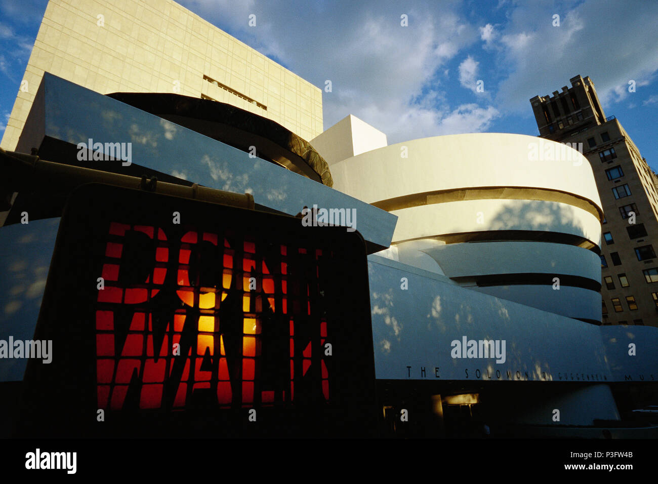 Manhattan, New York, USA. Ne marchez pas signe de la circulation et Musée Solomon R. Guggenheim sur la Cinquième Avenue, conçu par Frank Lloyd Wright. Banque D'Images