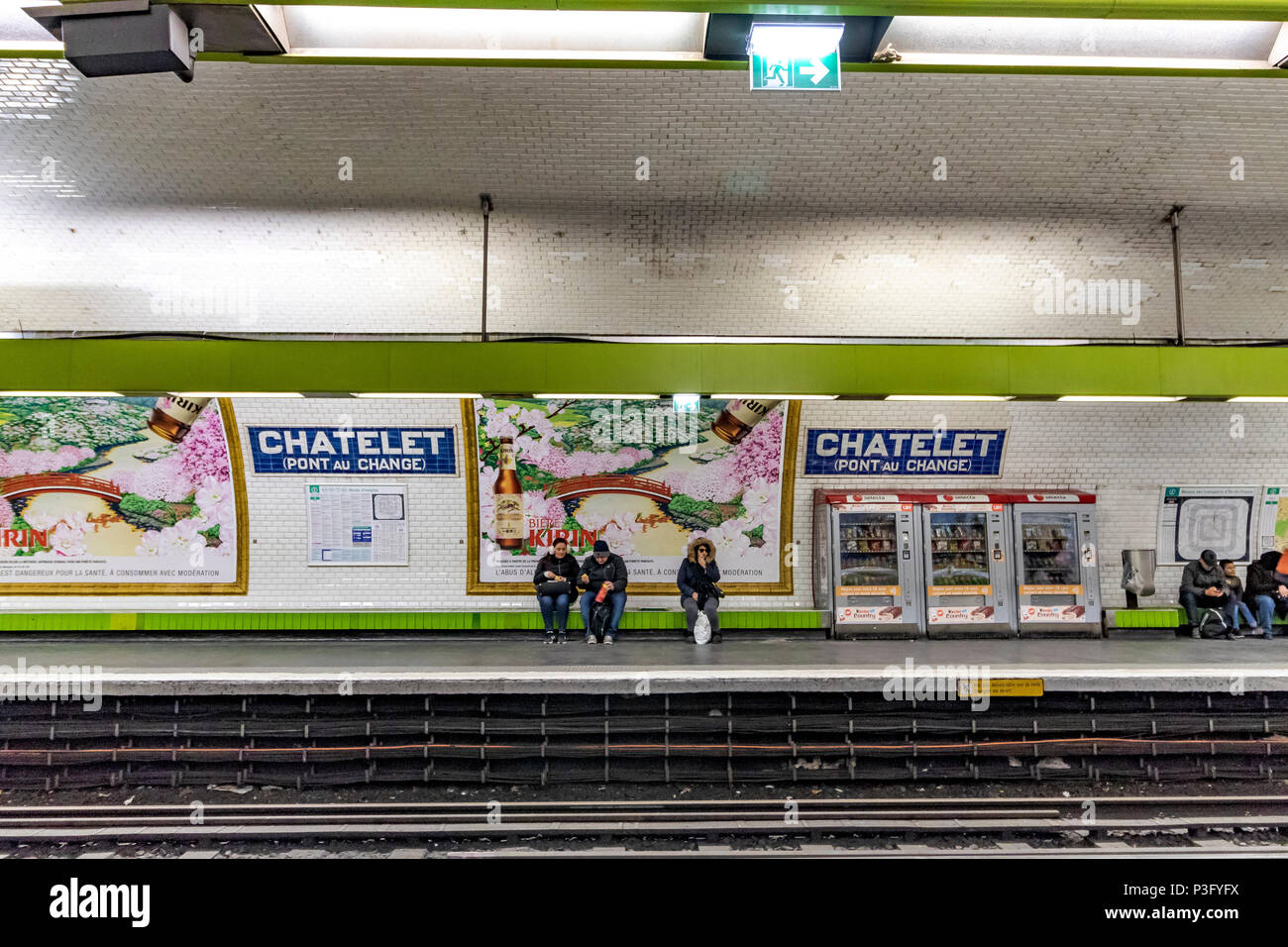 Des gens assis en attente d'un train sur la station Châtelet Pont au Change sur le métro de Paris, France Banque D'Images