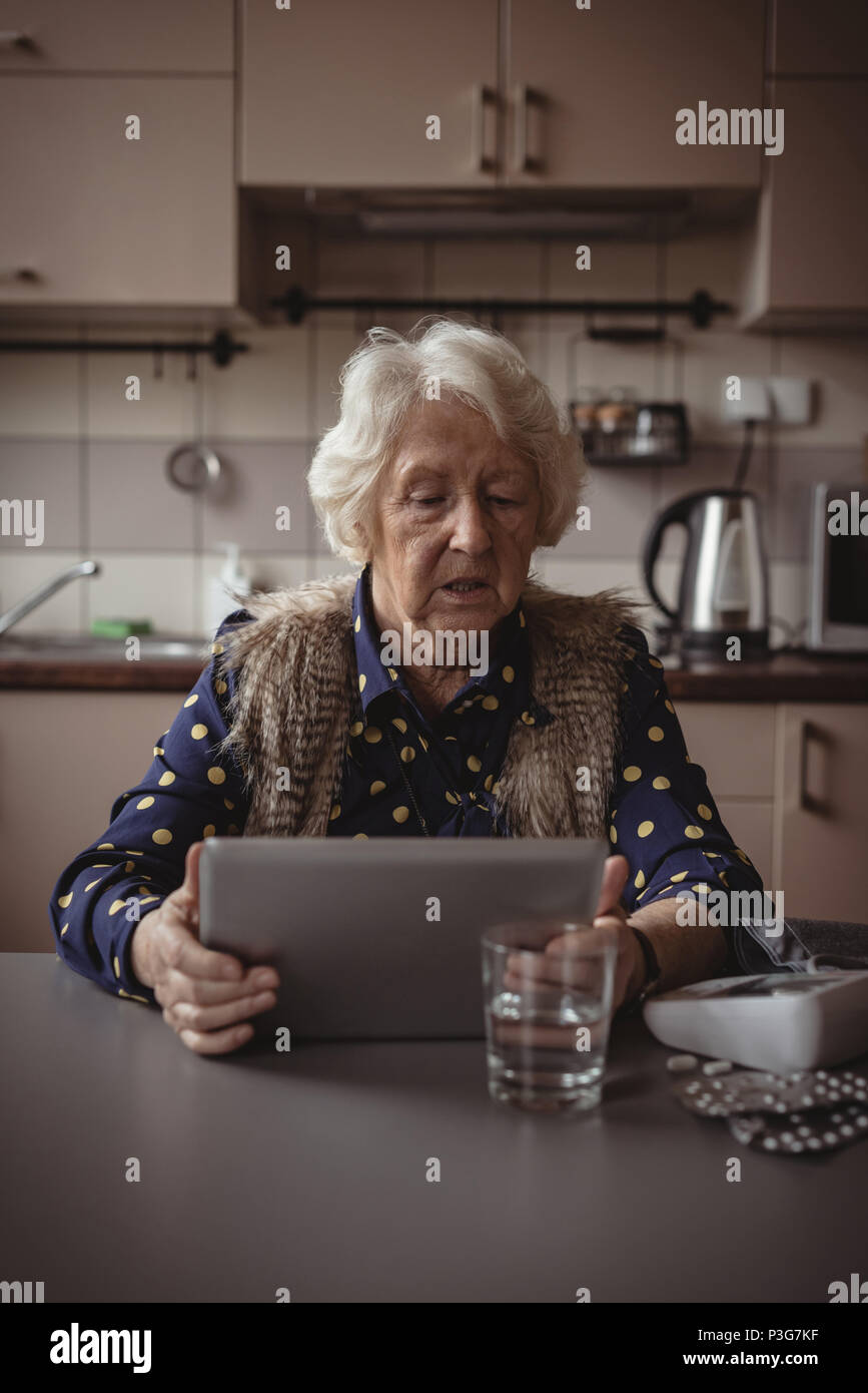 Senior woman using digital tablet in La cuisine Banque D'Images