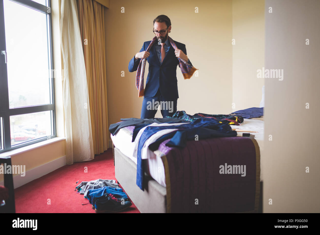 Businessman wearing sa cravate dans la chambre d'hôtel Banque D'Images