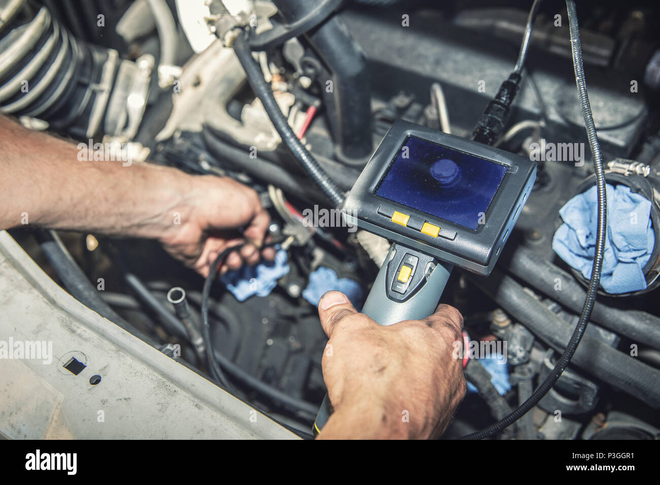 Mécanicien de voiture vérifier le moteur du véhicule avec caméra endoscopique Banque D'Images