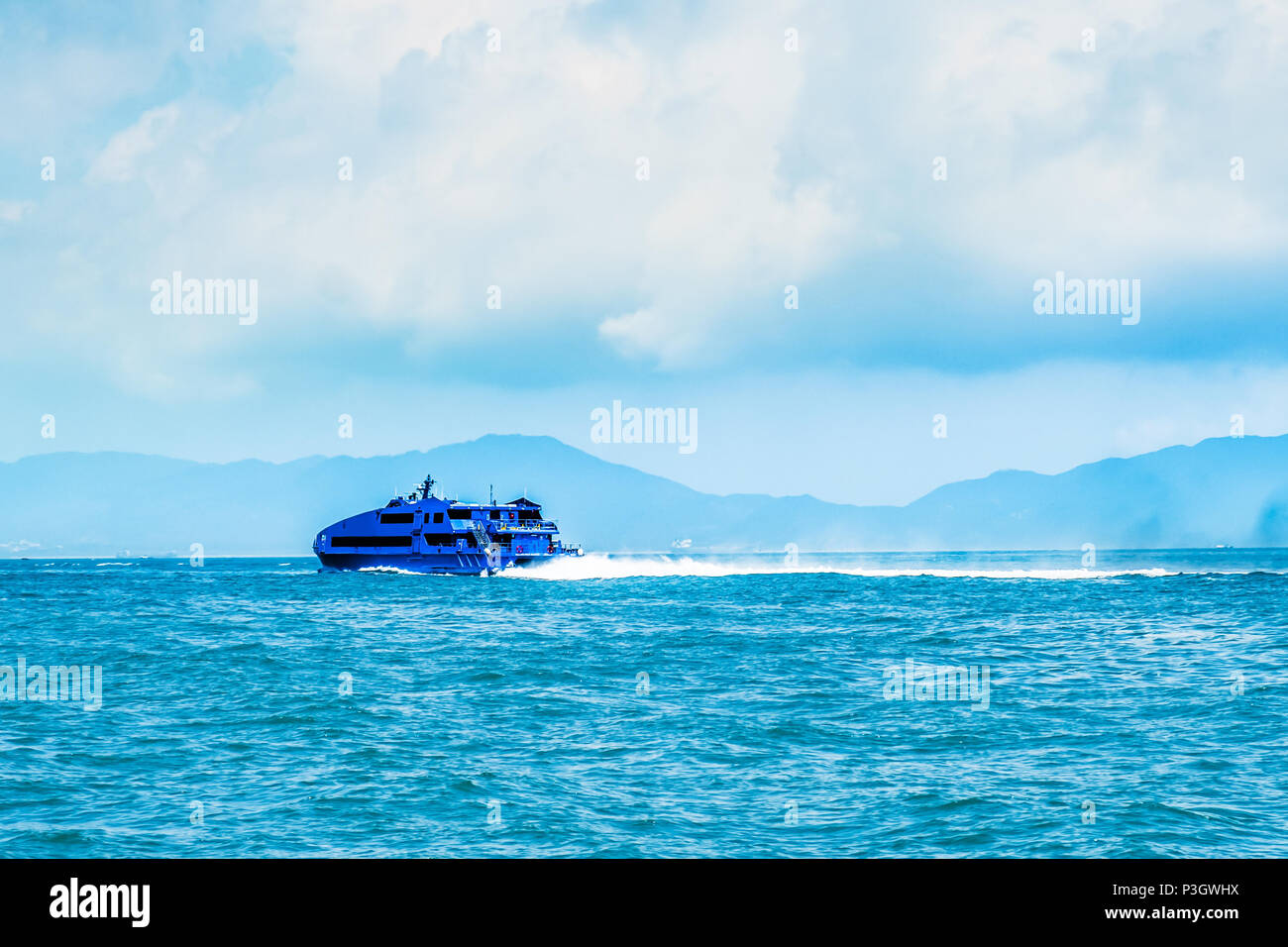 Jet d'eau à grande vitesse bateau nautique passagers se déplaçant rapidement de Hong Kong à Macao (jeu d'Asie centrale). Journée ensoleillée, ciel nuageux. Des voyages en Asie. Banque D'Images