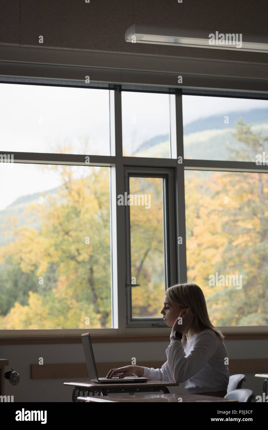 Teenage girl using laptop in classroom Banque D'Images