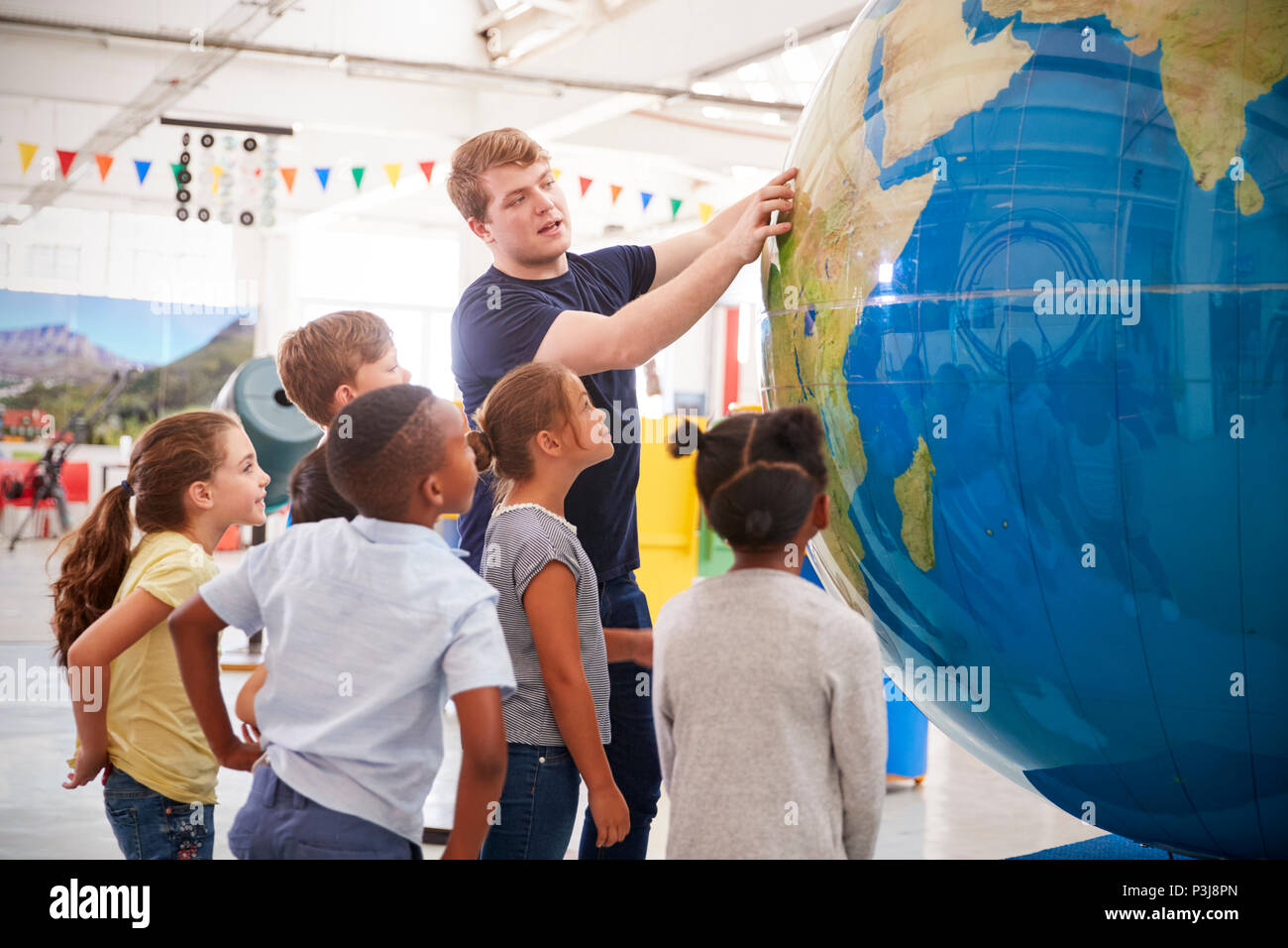 Enfants regarder présentation avec globe géant dans un centre des sciences Banque D'Images