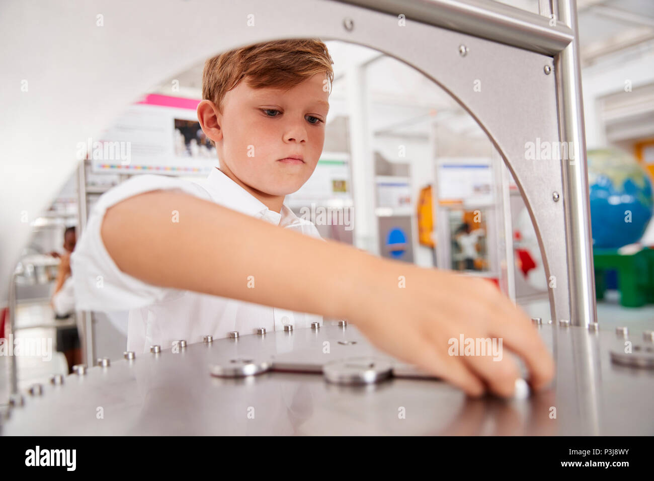 Écolier prenant part à un test de sciences dans un centre des sciences Banque D'Images