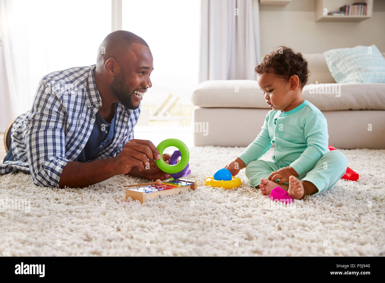 Papa noir et petit garçon jouant sur le plancher à la maison, Close up Banque D'Images