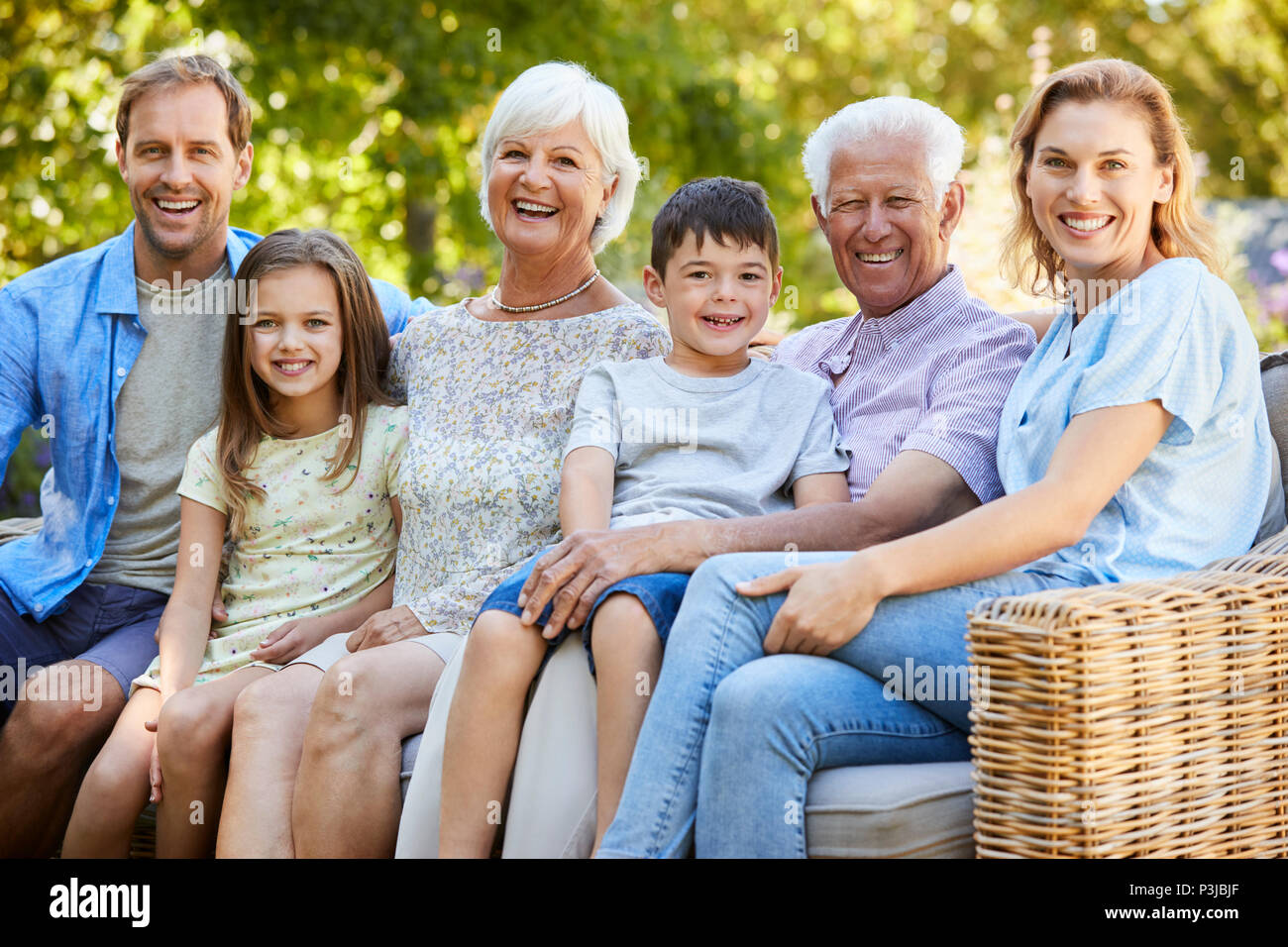 Family assis ensemble dans le jardin Banque D'Images