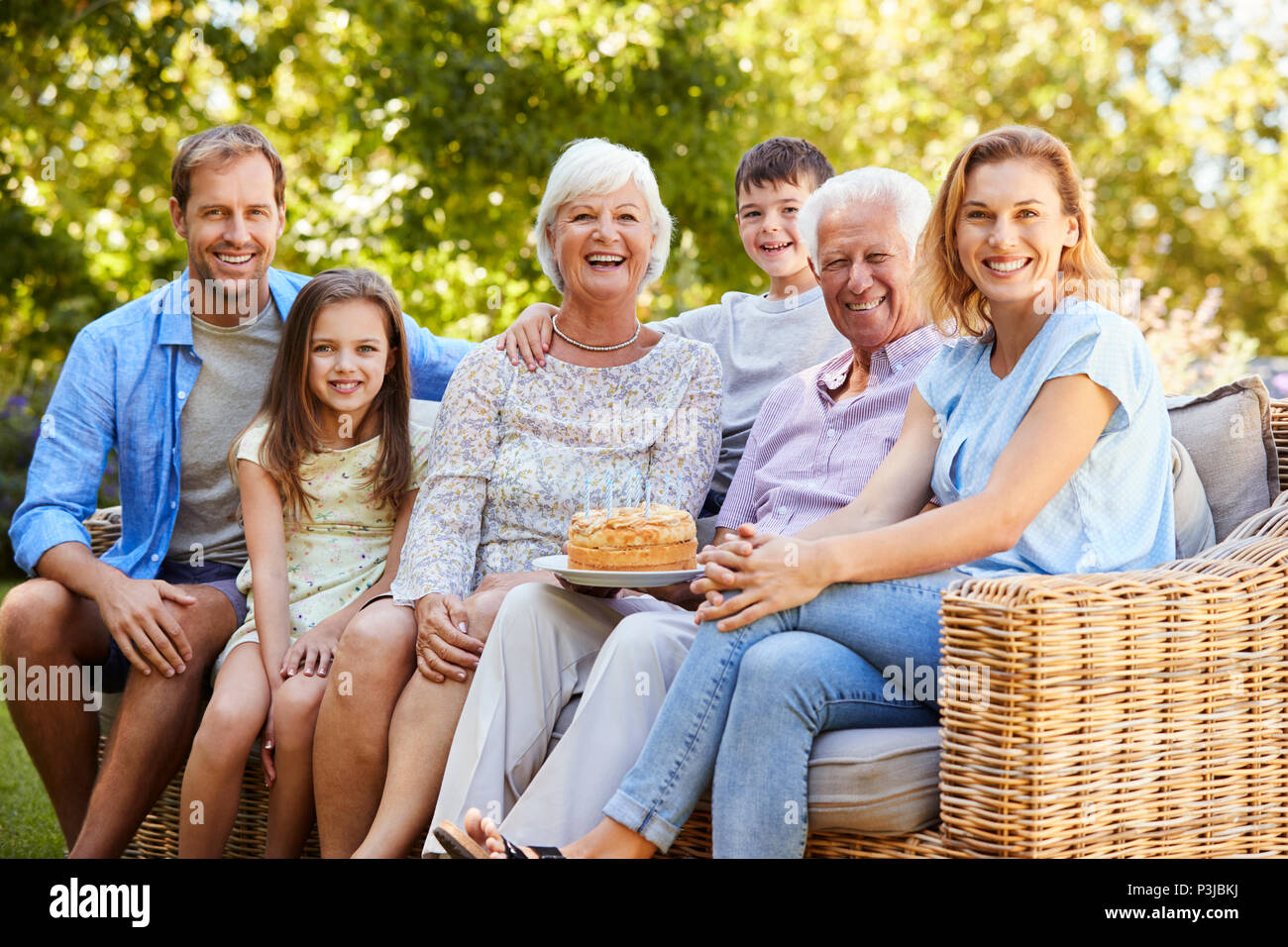 Family assis ensemble dans le jardin Banque D'Images