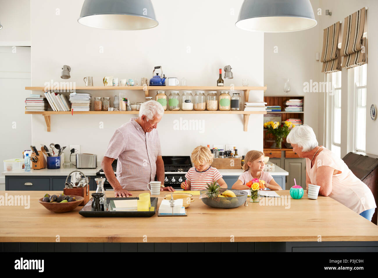 Grands-parents et leurs petits-enfants de parler dans la cuisine Banque D'Images