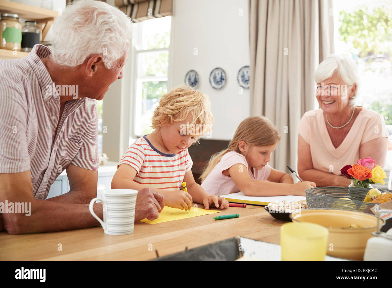 Les grands-parents avec petits-enfants souriant dans la cuisine, Close up Banque D'Images