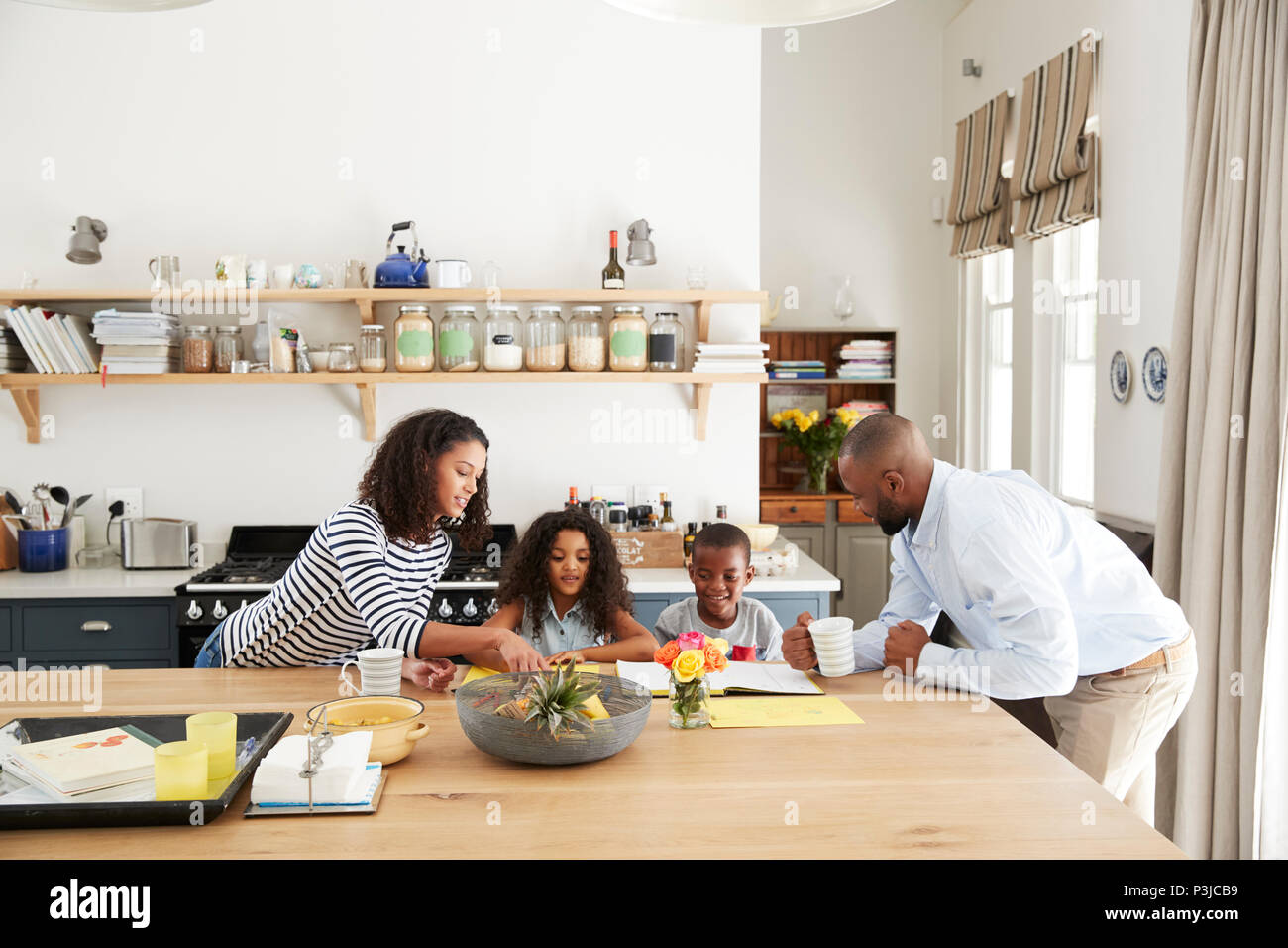 Jeune noir occupé la famille ensemble dans leur cuisine Banque D'Images