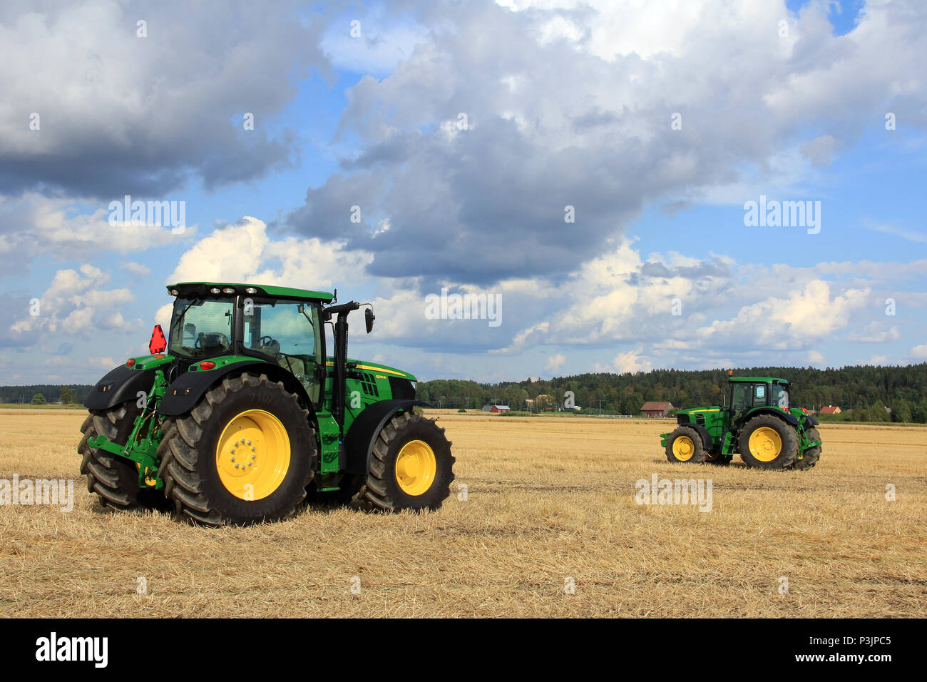 Deux modèles, les tracteurs John Deere 6210R et 6930 sur l'affichage sur des champs de Salo, Finlande, août 2012. Image éditoriale. Banque D'Images