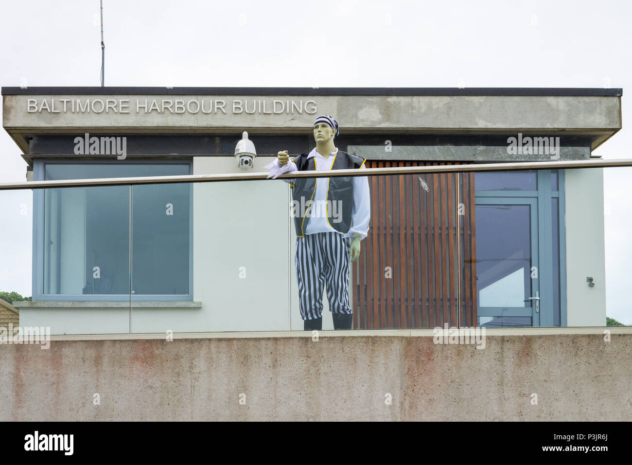 Pirate et donnant sur le port de Baltimore, en Irlande. Une partie de la semaine le faux pirate dans pirates costume monte la garde à l'extérieur du port de bureaux. Banque D'Images