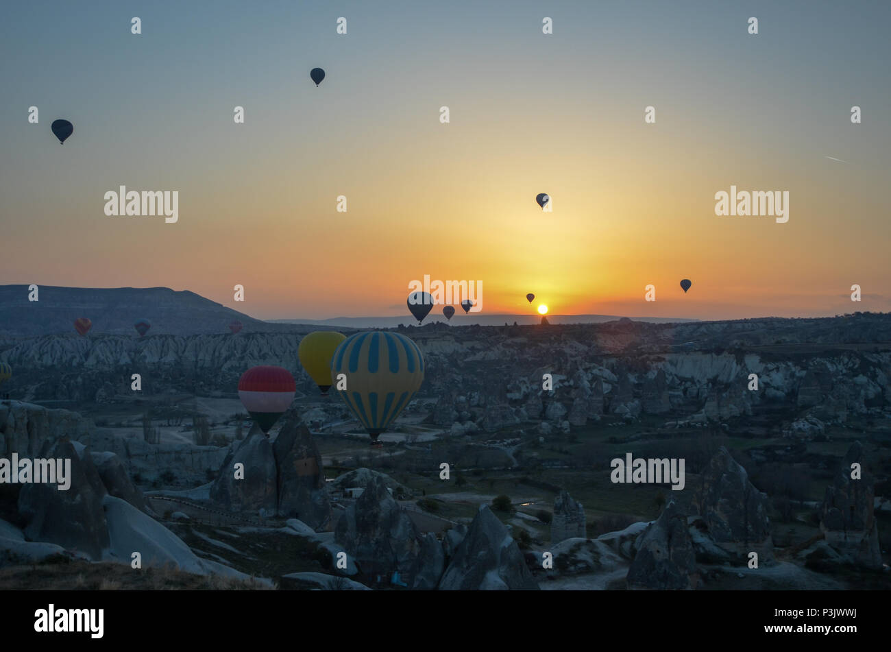 Sunrice montgolfières atterrissage dans une montagne du parc national de Göreme Cappadoce Banque D'Images