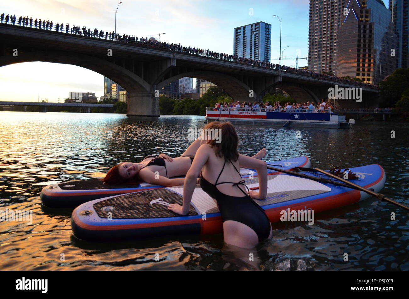 Deux filles paddle dans la soirée pour regarder la le Congrès ave les chauves-souris sortent sur le lac Coccinelle à Austin, Texas. Banque D'Images