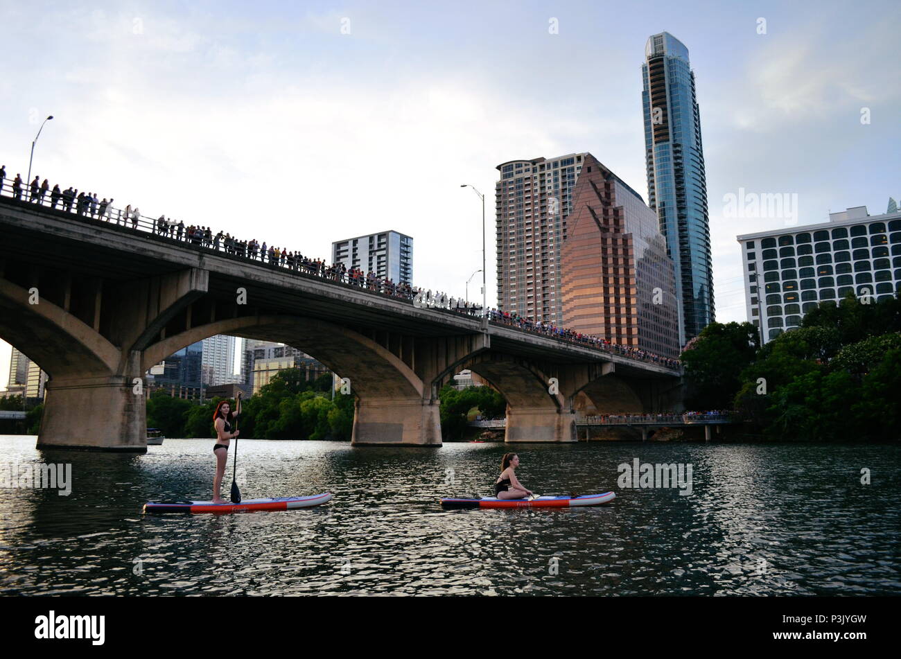 Deux filles paddle dans la soirée pour regarder la le Congrès ave les chauves-souris sortent sur le lac Coccinelle à Austin, Texas. Banque D'Images